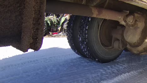 heavy duty driveshaft and differential on a grain truck moving around a snowy farmyard