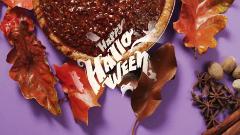 happy halloween text animation over autumn leaves and pie on purple background