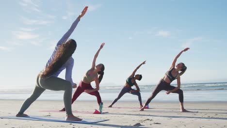 Grupo-De-Amigas-Diversas-Practicando-Yoga-En-La-Playa