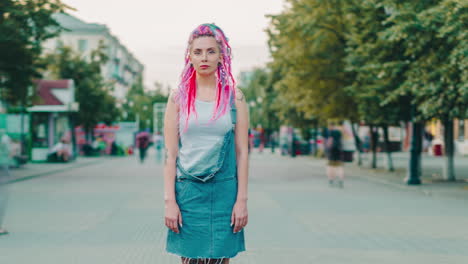 young woman with pink dreadlocks in a city street