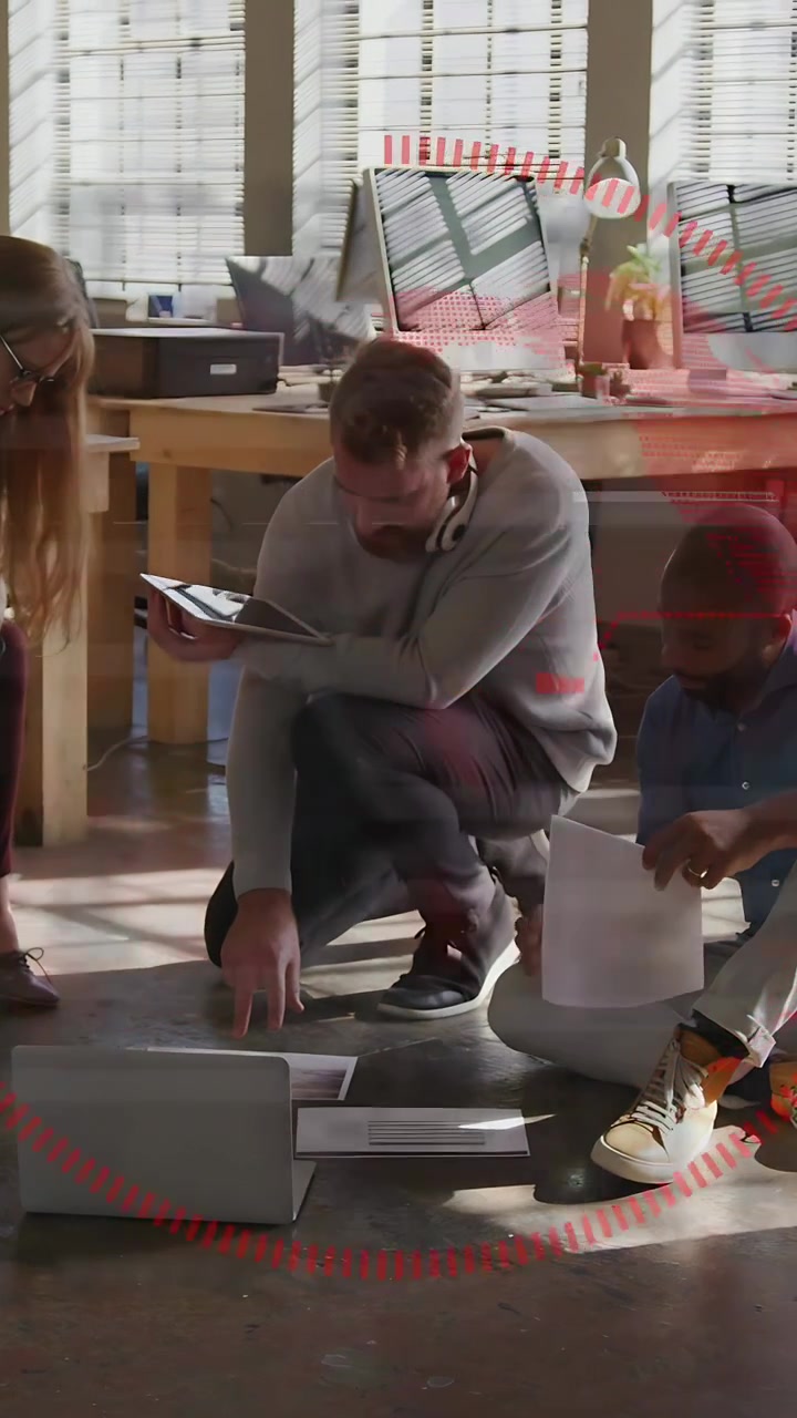 Vertikal video: Hukket leder tapper på tablet, organiserer papirer til design, mens rød HUD vokser