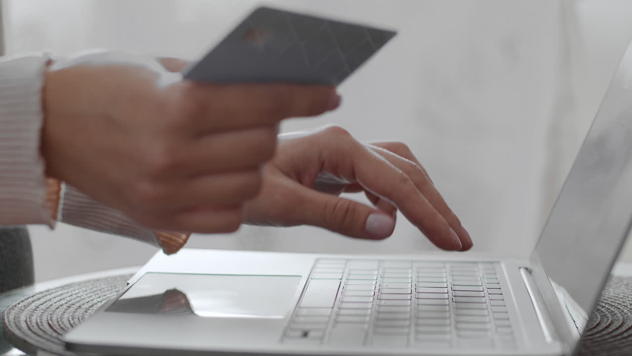 Woman making online payment with credit card on laptop