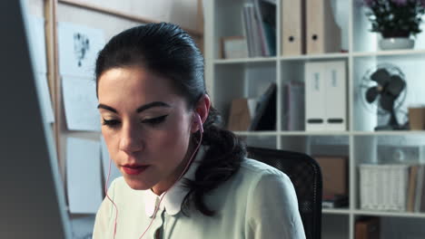 Woman-using-computer-video-messaging-late-at-night-home-office