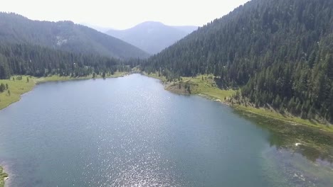 aerial - drone flies closer to the clear blue water