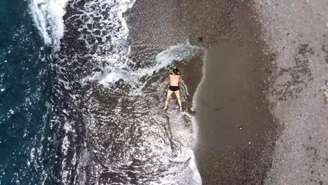 lying-on-vlychada-beach-in-santorini-greece