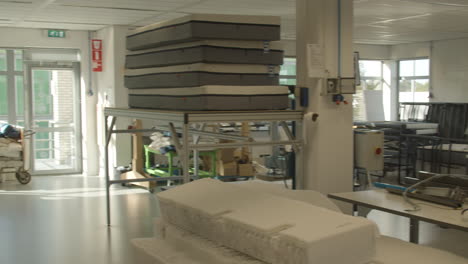 taller de fabricación de sartenes sobre colchones con máquinas para pruebas y producción.