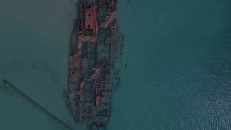 4K-overhead-clip-taking-off-over-a-shipwreck-in-the-tropical-beach-of-Epanomi,-Norhtern-Greece