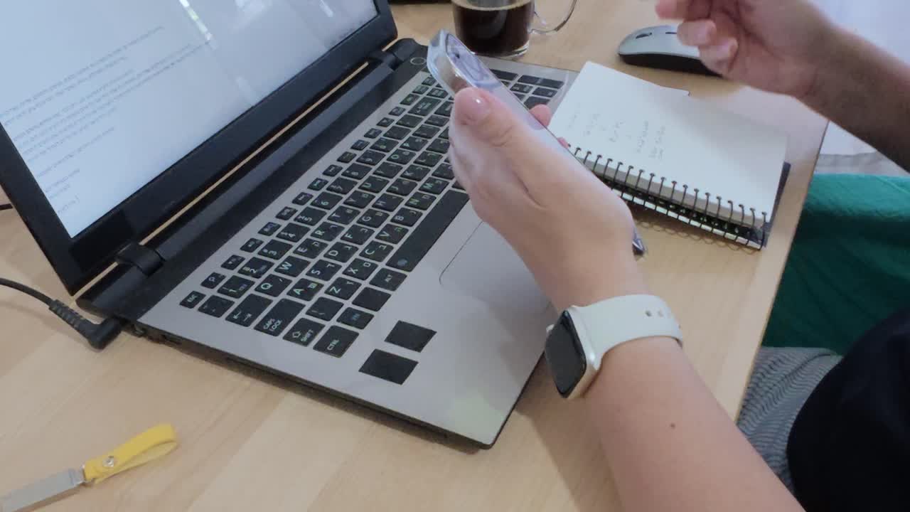 A person is using a laptop and a cell phone