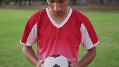 video of biracial football player with ball on field