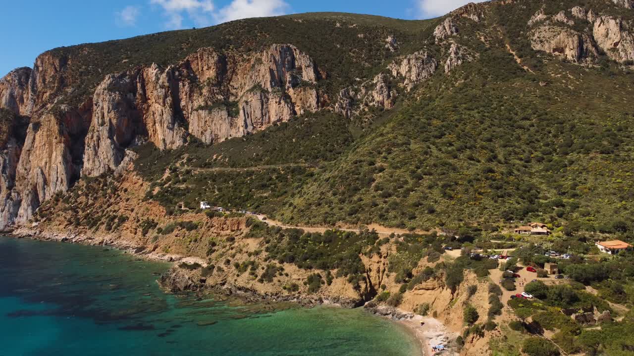 Masua coastline aerial view, turquoise sea water by steep mountain, Sardinia