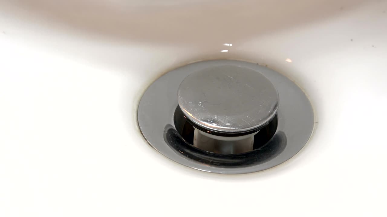 el agua gira por un desagüe del fregadero.