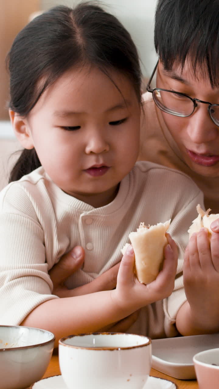 Father and Daughter Eating Baozi