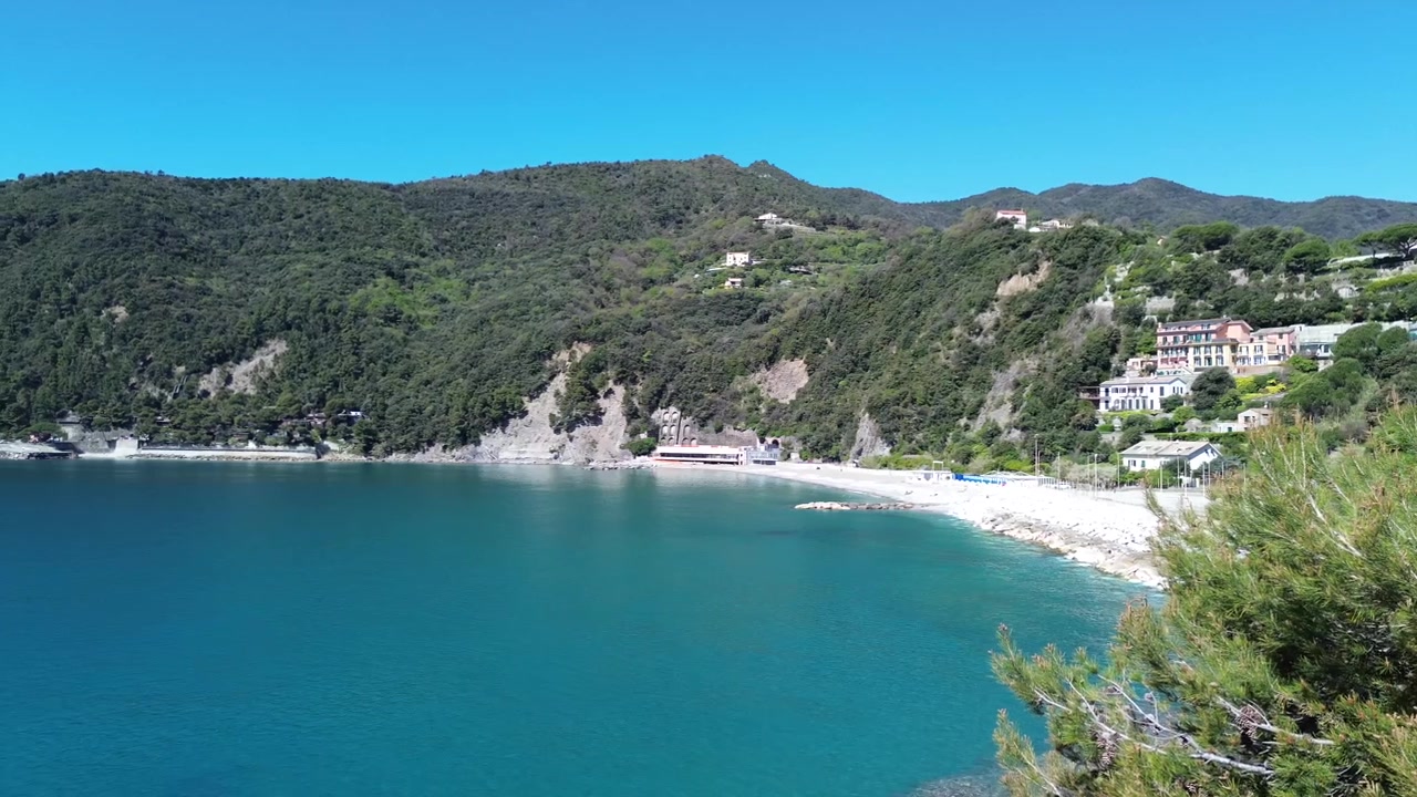 Vista aerea cinematografica di acque cristalline e paesaggi costieri frastagliati nelle Cinque Terre, Italia.
