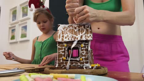 family decorating a gingerbread house