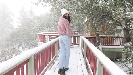 a young female model walks on a bridge in the snow