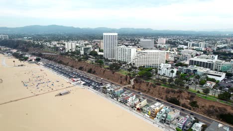 Vista-Aérea-Volando-A-Través-Del-Bulevar-De-Santa-Monica,-California-Arena-Dorada-Playa-Resort-Costa