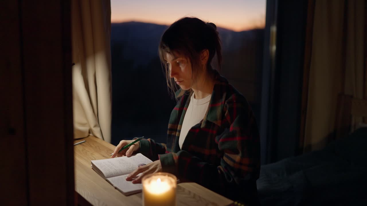 Donna che scrive un diario in un furgone accogliente al tramonto