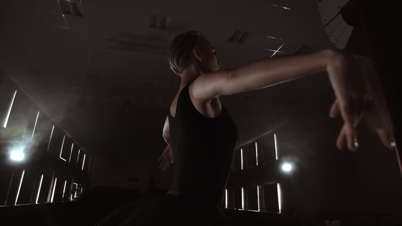 A ballerina dances in a hall with empty seats. A female dancer enjoys the quiet of an empty scene and no audience