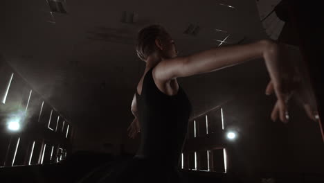 a ballerina dances in a hall with empty seats. a female dancer enjoys the quiet of an empty scene and no audience