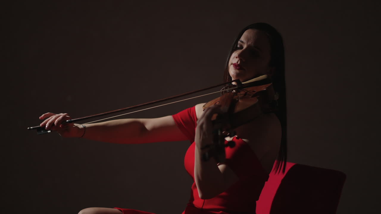 mujer tocando el violín en vestido rojo