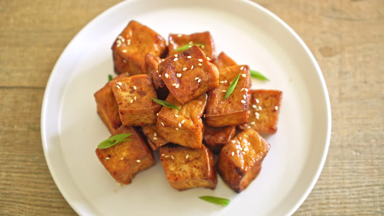 tofu frito con sésamo blanco y salsa teriyaki - estilo de comida vegana y vegetariana