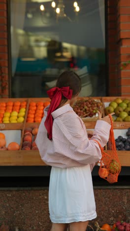 woman shopping for fruit at a market