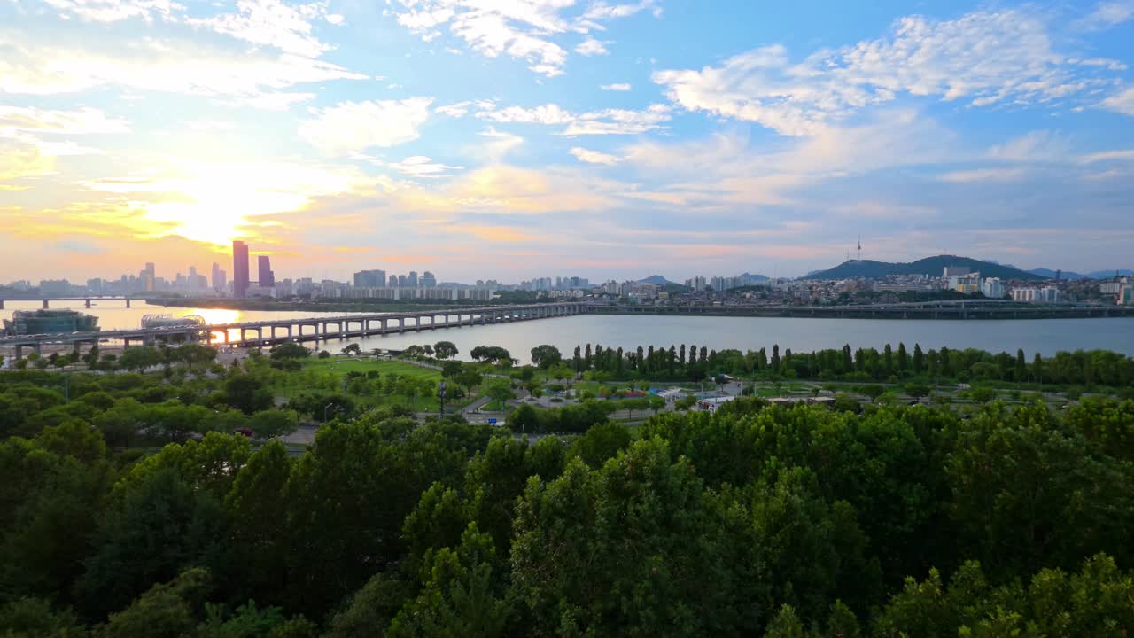 Scenic summer sunset in Seoul with Banpo Bridge and Namsan Tower skyline, sunlight reflecting in Han River