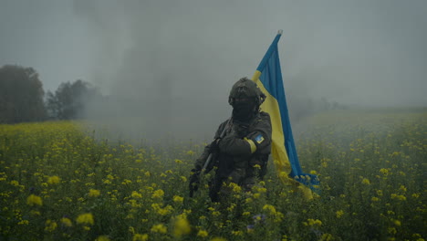 Ukrainian soldier with flag in a field