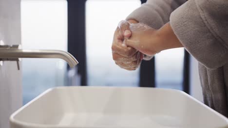 cerca mujer afroamericana de talla grande lavándose las manos en el baño, cámara lenta