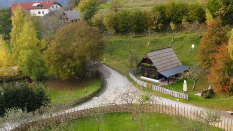 aerial approaching small rustic house, charming wood fence