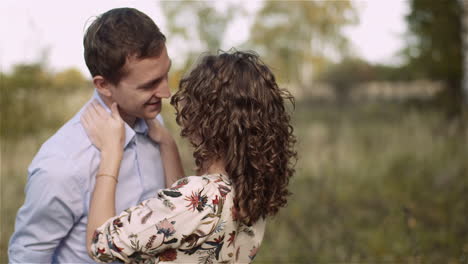 couple hugging and walking on a meadow in summer at sunset 6