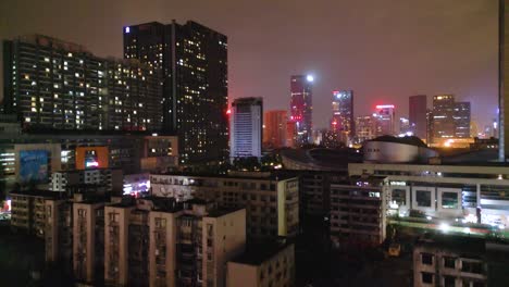 nighttime aerial view of old chinese residential buildings with modern skyscrapers
