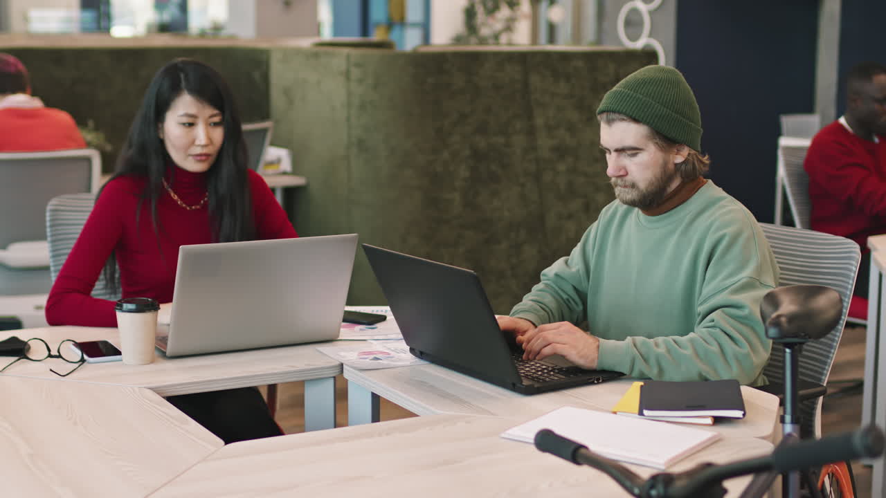 Businesspeople Working on Laptops in Coworking Space