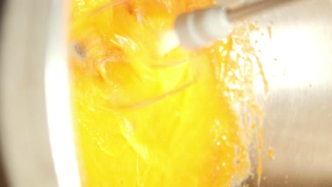 mixing a vibrant orange/yellow liquid in a bowl