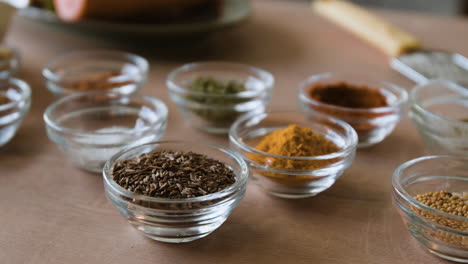assortment of spices and herbs in small glass bowls