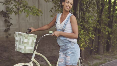 woman posing with bicycle at street