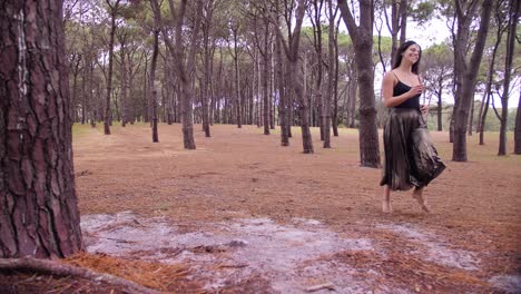 una mujer bonita corriendo alegremente entre los árboles altos en el parque centenario en sydney, australia, después de su ensayo de baile - plano general