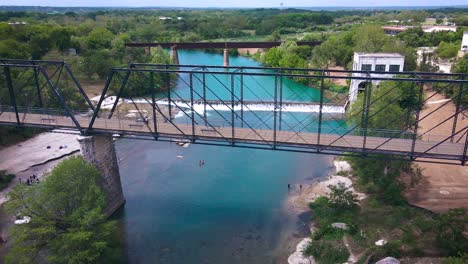 drone footage of the historic faust street bridge in new braunfels, texas that goes over the guadalupe river near interstate 35