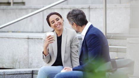 hombre de negocios y mujer de negocios se reúnen al aire libre bebiendo café para llevar y hablando