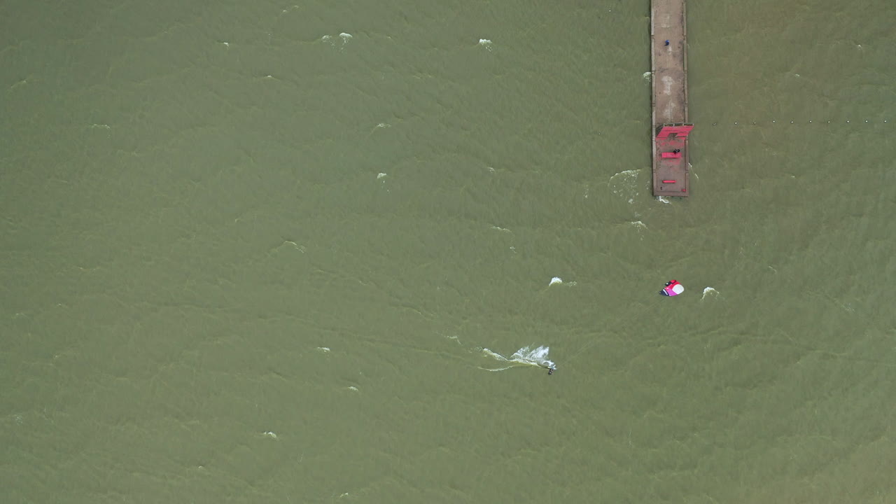 вид сверху на серфингиста, катающегося на зеленой волне балтийского моря