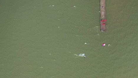 AERIAL:-Top-View-of-Surfer-Riding-Green-Wave-of-Baltic-Sea