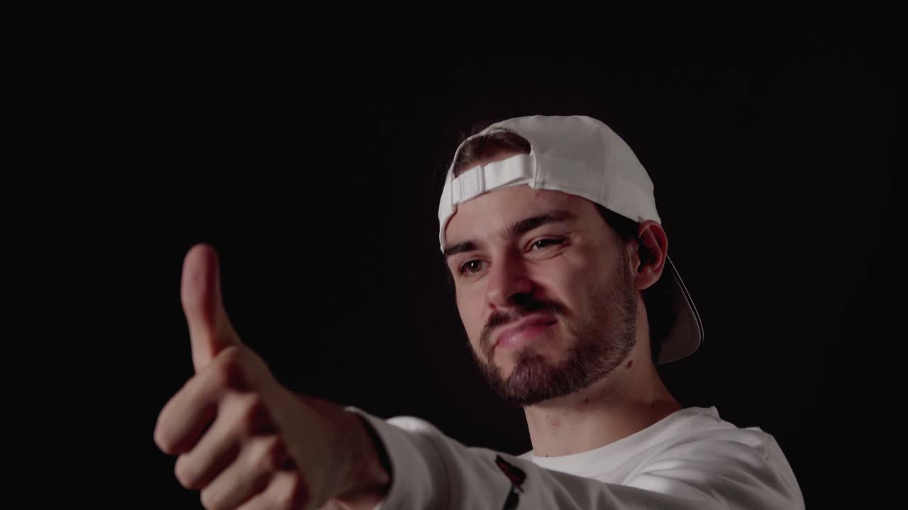 엄지손가락을 치켜드는 세련된 20대 남자, 감사하는 몸짓, 가까운, 검정색 배경