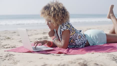 mujer en la playa usando una computadora