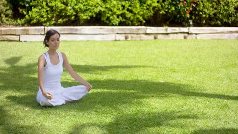 Lovely-young-woman-meditating-in-the-garden