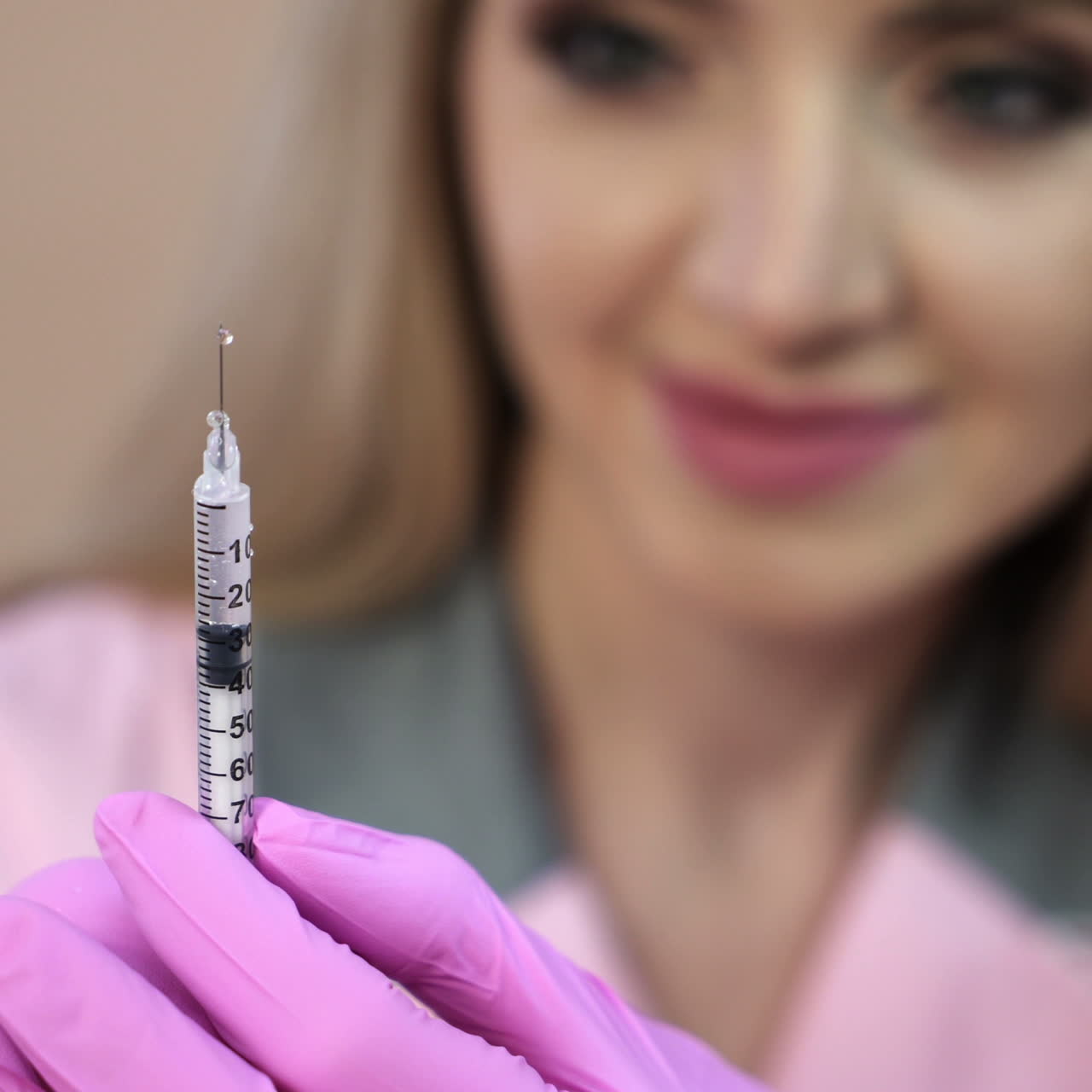 Doctor in a dressing gown and gloves, preparing an injection syringe.