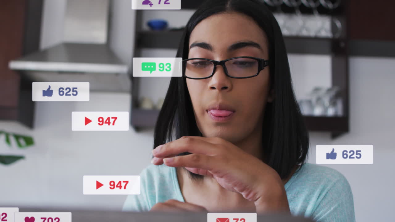 animación de iconos y números de redes sociales sobre una mujer biracial usando una computadora portátil