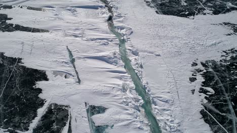 aerial above the deep crack on snow covered frozen ice surface of lake baikal. natural landmark. winter landscape. popular touristic destination. high angle view.