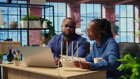 african american couple at home office troubleshooting their wi fi modem