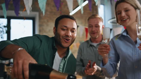 excited colleagues clinking glasses with wine celebrating in office close up.