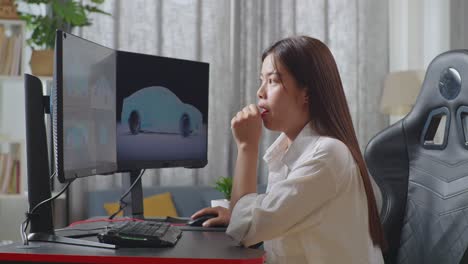 side view of asian female automotive designer yawning while working on 3d model of ev car on the desktop computers in the studio